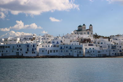 Sea by cityscape against sky