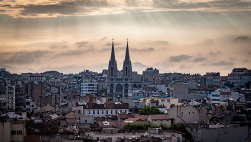 Buildings in city against cloudy sky