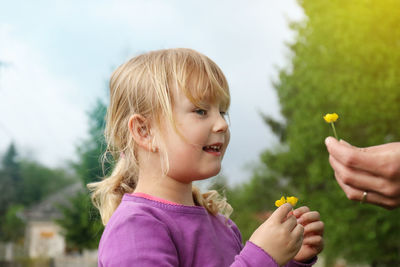 Portrait of woman holding girl with plants