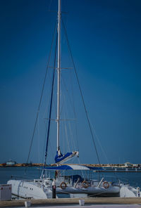 Sailboats sailing on sea against clear blue sky