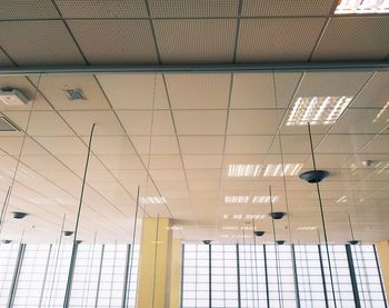 Low angle view of illuminated lights on ceiling of building
