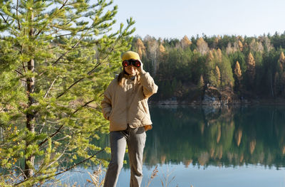 Full length of woman standing against lake