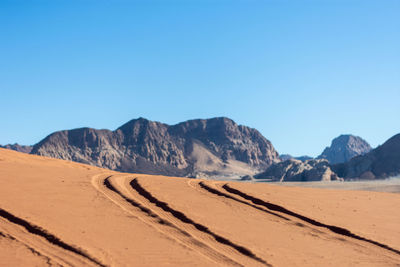 Scenic view of desert against clear blue sky