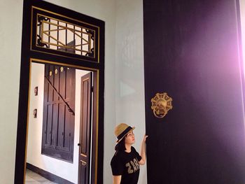 Woman standing by window at home