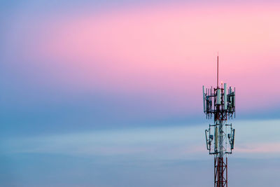 Low angle view of communications tower against sky during sunset