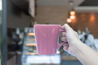 Close-up of hand holding coffee cup