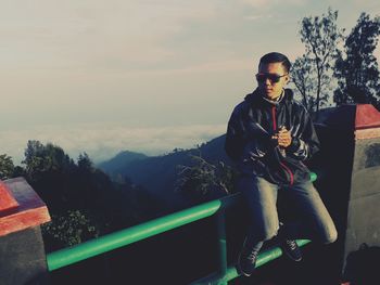 Man riding bicycle on mountain against sky