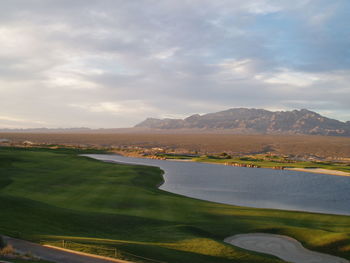 Scenic view of golf course against sky