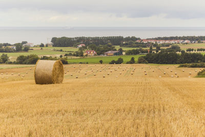 Hay bales on field against sky