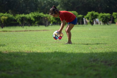 Woman playing soccer ball on grass