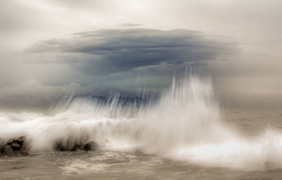 Scenic view of waterfall against sky