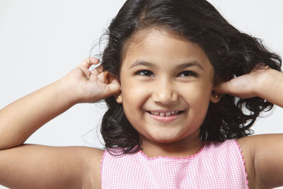 Smiling girl with hand in hair over white background