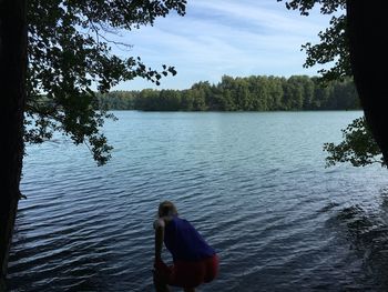 Rear view of man standing on riverbank