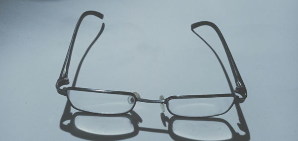 High angle view of eyeglasses on table against white background