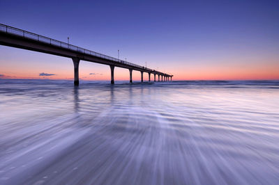 Pier over sea against sky during sunset