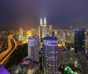 Mid distance view of illuminated petronas towers in city at dusk