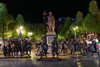 Illuminated statues at night in city