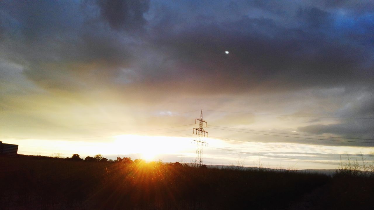 SILHOUETTE ELECTRICITY PYLON ON LAND AGAINST SKY DURING SUNSET