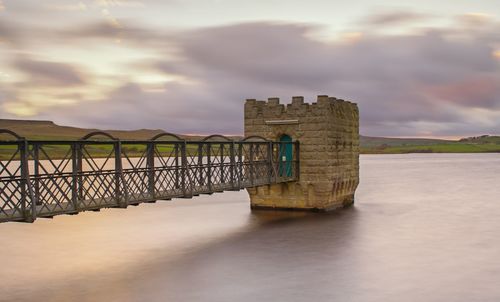 Built structure by sea against sky