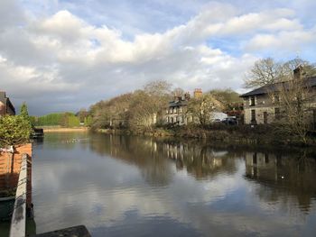 Scenic view of lake by buildings against sky