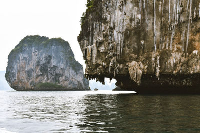 Scenic view of rock formation in sea against clear sky