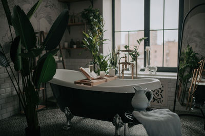 Luxury interior of big bathroom at modern african style with oval bathtub in natural lighting