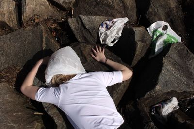 High angle view of woman lying on rock