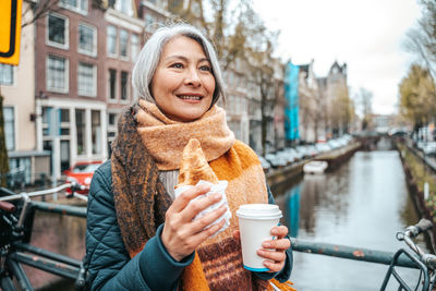 Portrait of smiling young woman drinking coffee