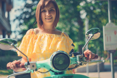 Portrait of a smiling young woman holding camera