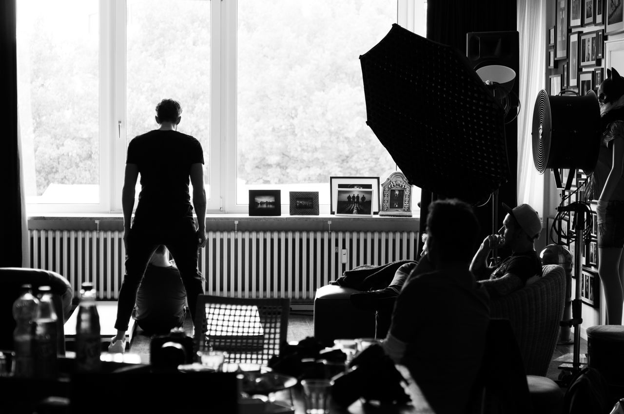 REAR VIEW OF MAN SITTING ON TABLE