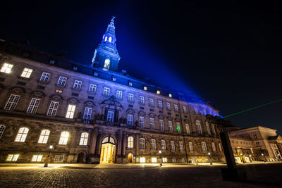 Low angle view of illuminated buildings against sky at night