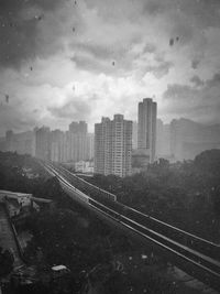 Railroad tracks against cloudy sky
