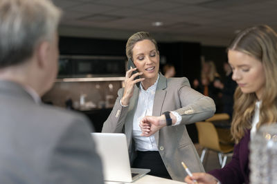 Businesswoman talking via cell phone in office