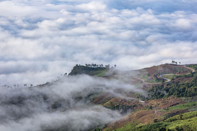 Scenic view of mountains against cloudy sky during foggy weather