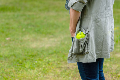 Rear view of man with umbrella walking on grass