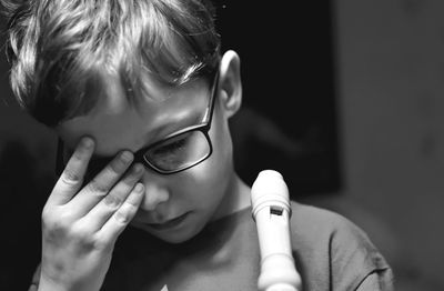 Close-up of tired boy wearing eyeglasses at home