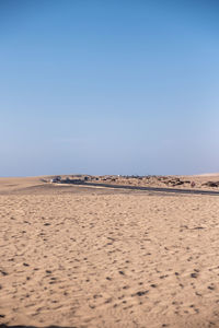 Scenic view of desert against clear blue sky