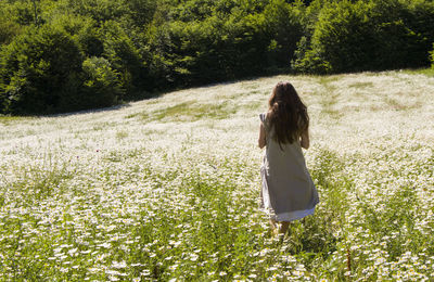 Rear view of woman standing on field