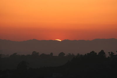 Scenic view of silhouette mountains against sky at sunset