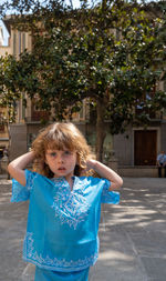 Portrait of cute girl standing against trees