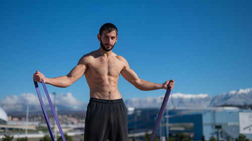 Portrait of young man standing against clear sky