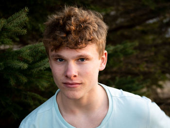 Portrait of young man against trees