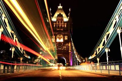 Road passing through illuminated city at night