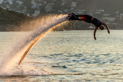 Man flyboarding in sea