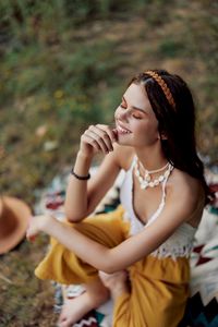 Portrait of young woman sitting on field