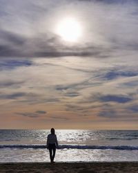 Rear view of woman standing on beach