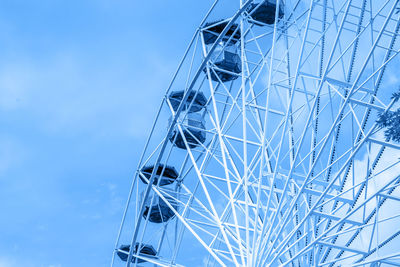 Low angle view of ferris wheel against blue sky