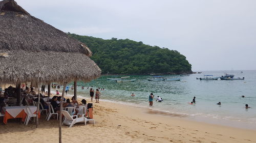Group of people on beach against sky