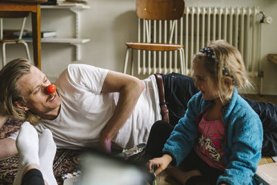 Father and daughter sitting on floor together