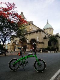 Bicycle parked by building against sky